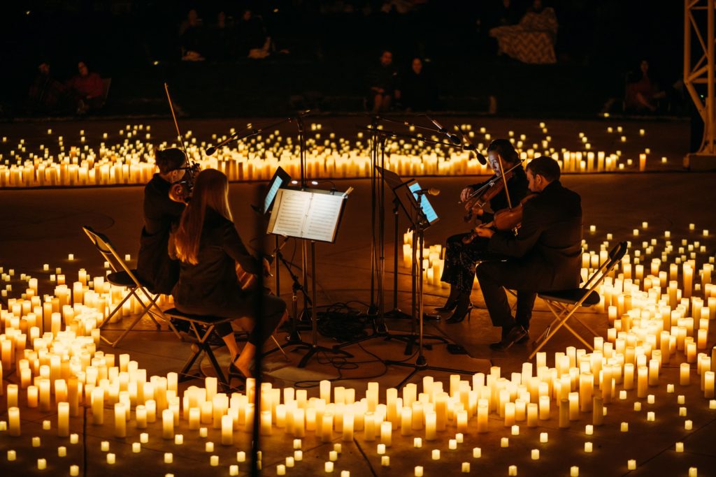 A string quartet performing in a circle surrounded by hundreds of candles at a Candlelight concert.