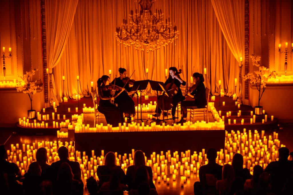 Ein Streichquartett auf der Bühne mit Kerzen im Hintergrund