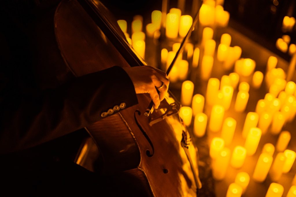 Musiker spielt Cello und ist von Kerzenmeer umgeben bei Candlelight-Konzert in Dresden