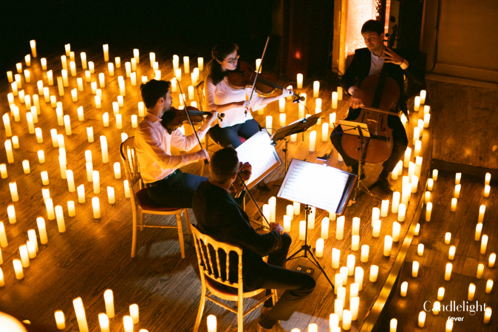Musicians playing instruments surrounded by candles