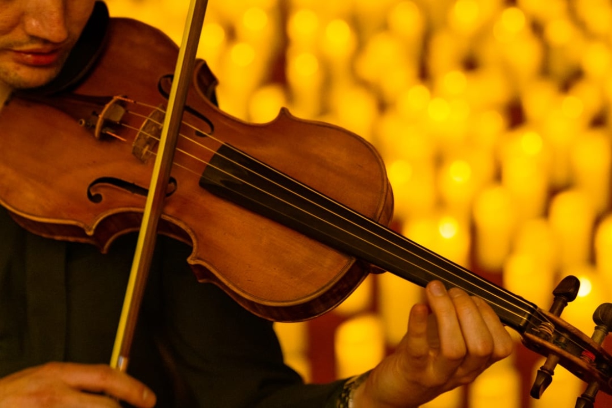Musiker spielt Violine im Hintergrund Meer aus Kerzen bei Candlelight-Konzert Nürnberg