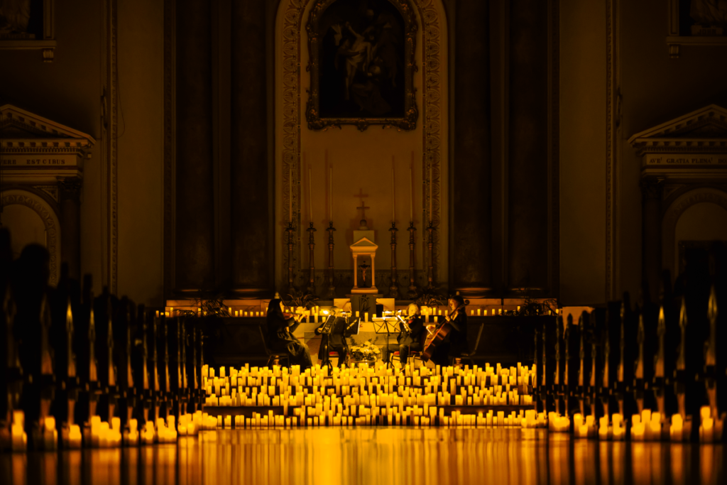 The aisle of and altar of a church bathed in the glow of hundreds of candles.