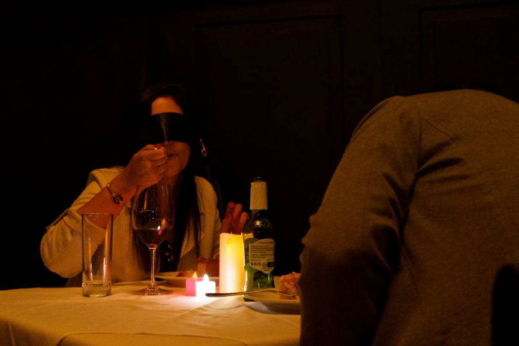 A guest takes a bite of food whilst blindfolded at a Dining In The Dark event.