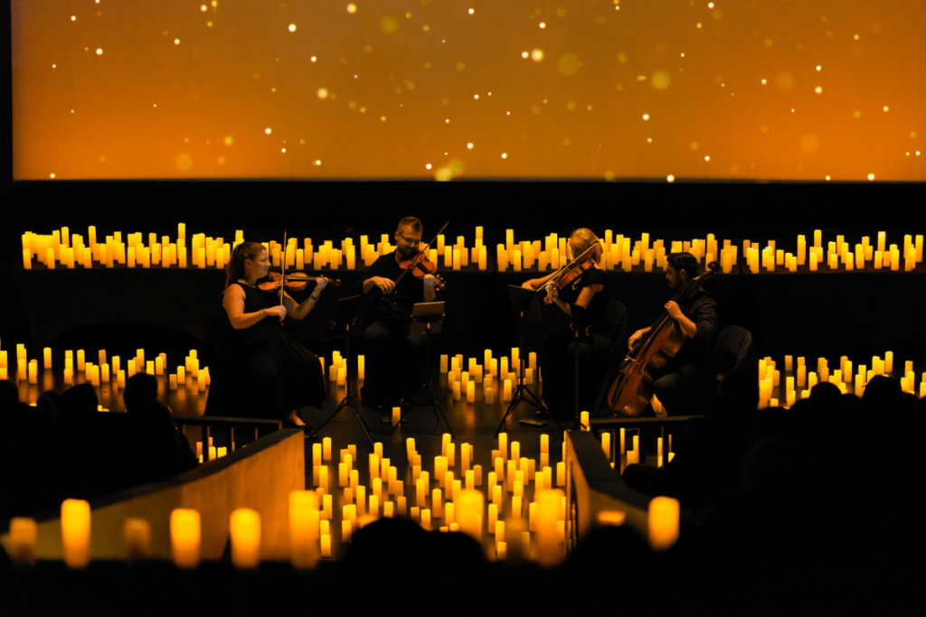 A string quartet performing surrounded by hundreds of candles.