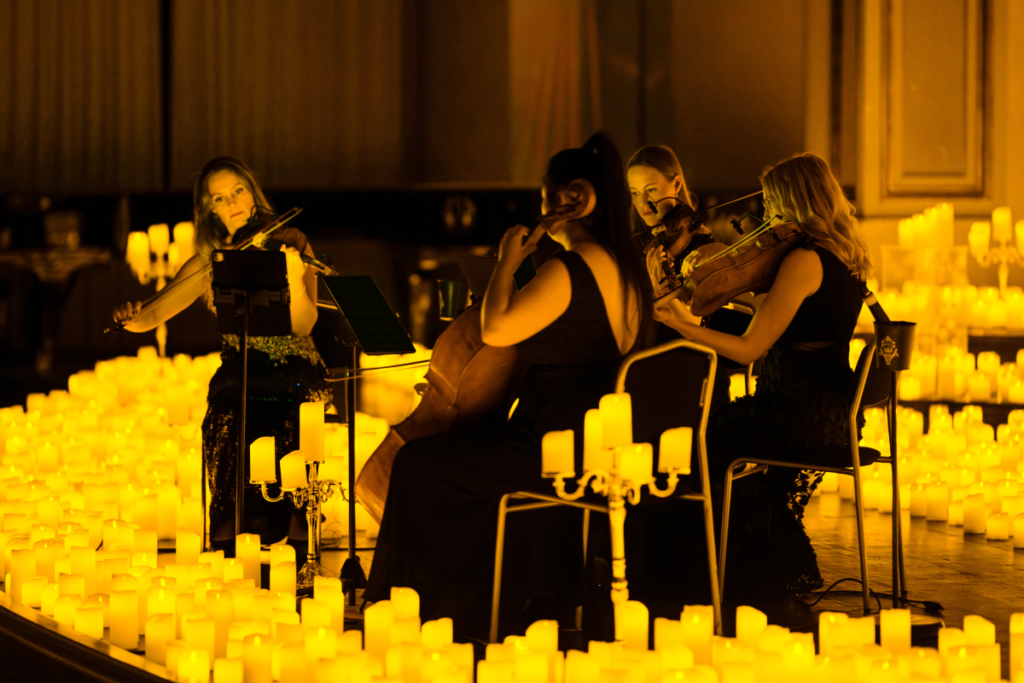 A string quartet performing in a candlelit hall