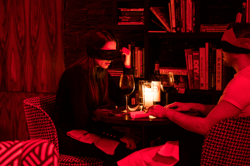 A couple having dinner blindfolded at the Dining in the Dark experience.