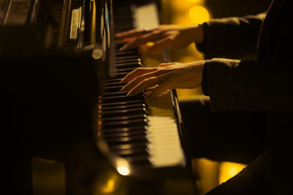 Photo en gros plan des mains d'un pianiste jouant du piano pour un concert