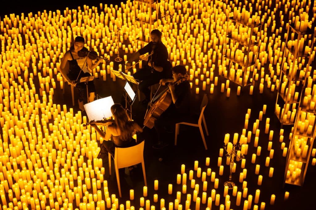 A string quartet performing surrounded by a sea of candles.