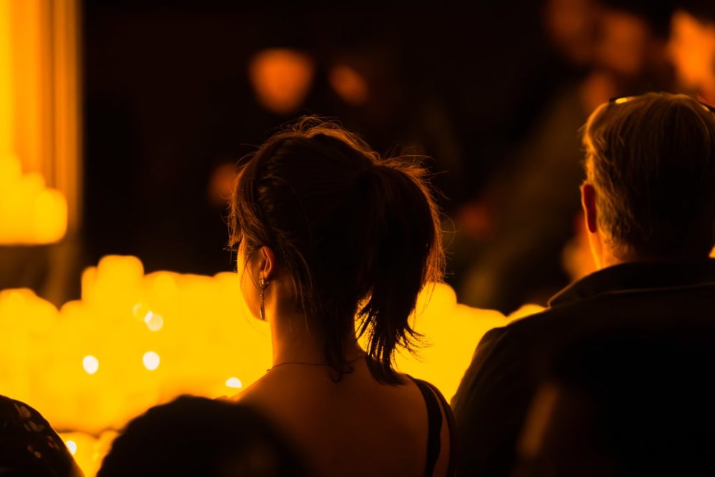 Photo du public de dos faisant face aux bougies d'un concert Candlelight