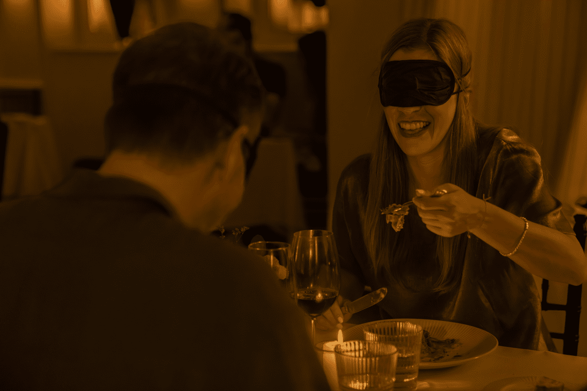 A couple who are blindfolded eating a meal at Dining in the Dark