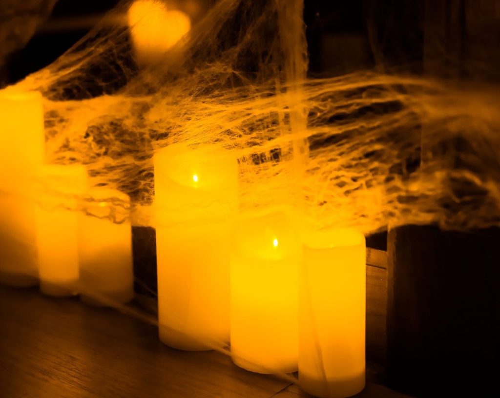 A set of candles wrapped up in a spider web