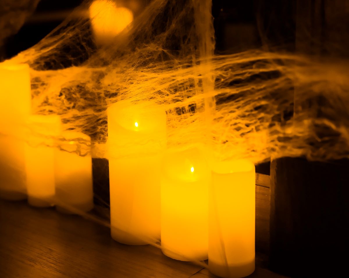 A close up of candles wrapped in webs for a Candlelight Halloween special.