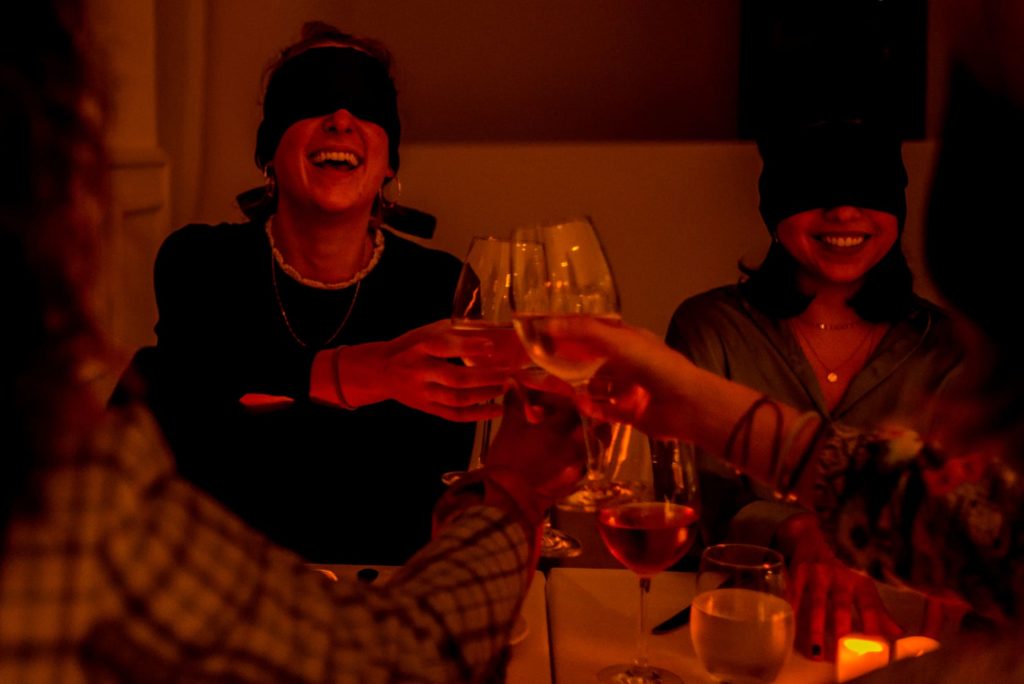Photo d'un dîner à l'aveugle avec un groupe d'amis triquants avec leurs verres les yeux bandés