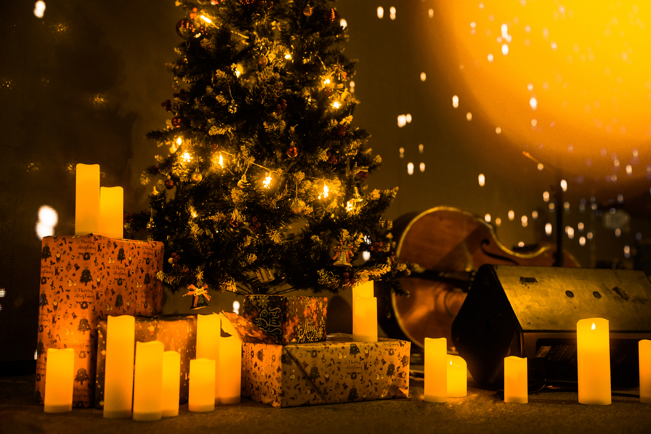 Árbol de navidad con violonchelo, velas y regalos envueltos