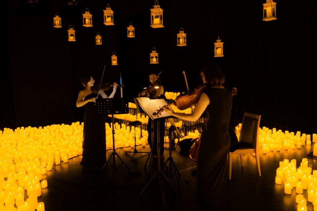 A string quartet performing a Candlelight concert surrounded by hundreds of candles.