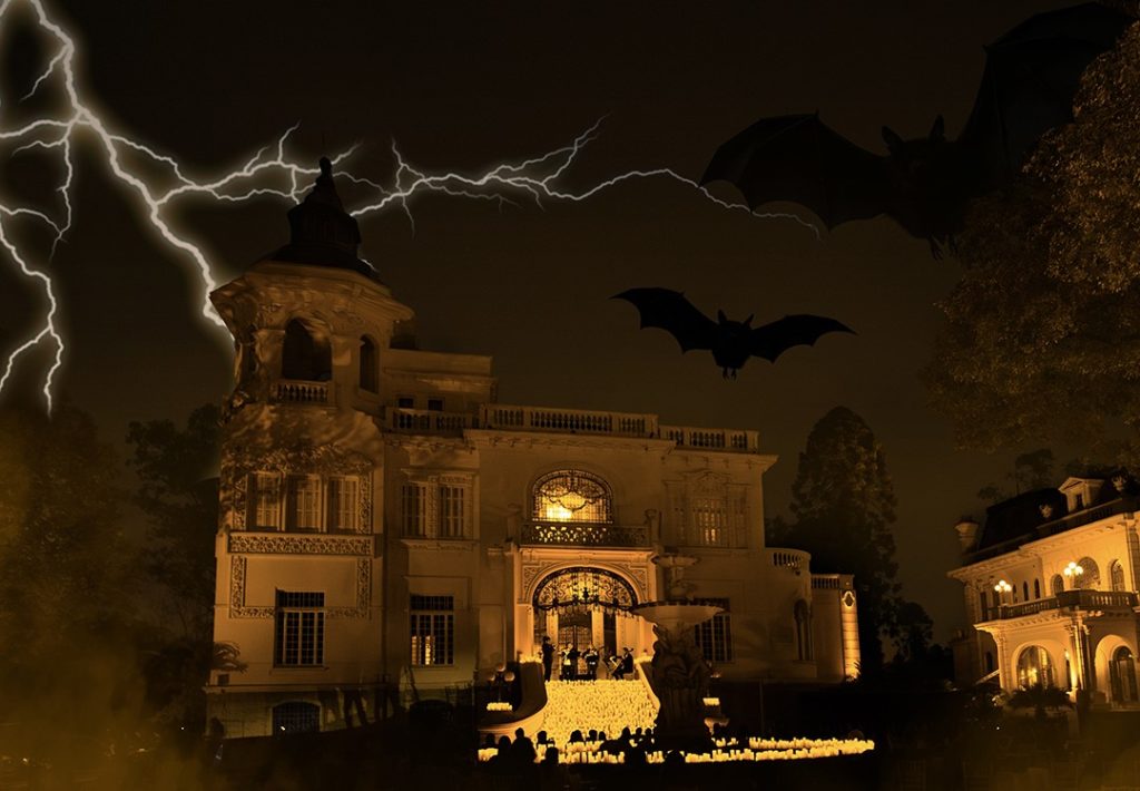 An image of a mansion lit up at night creating a spooky Halloween scene.