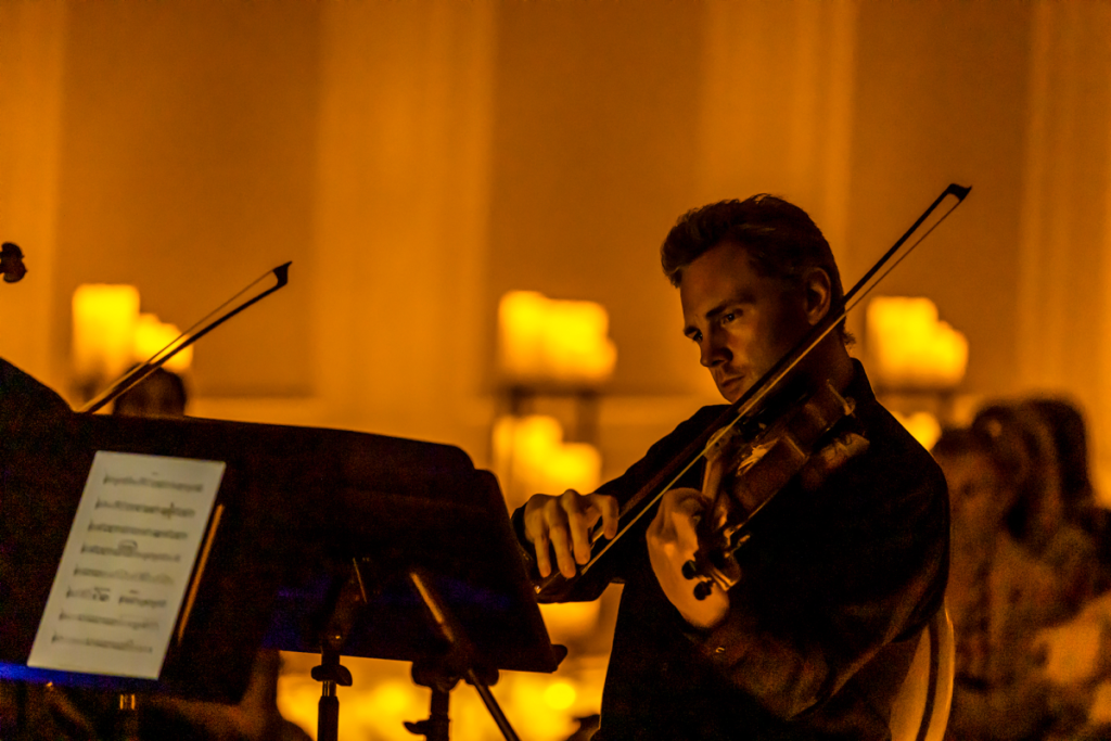 A musician playing the violin at a Candlelight concert