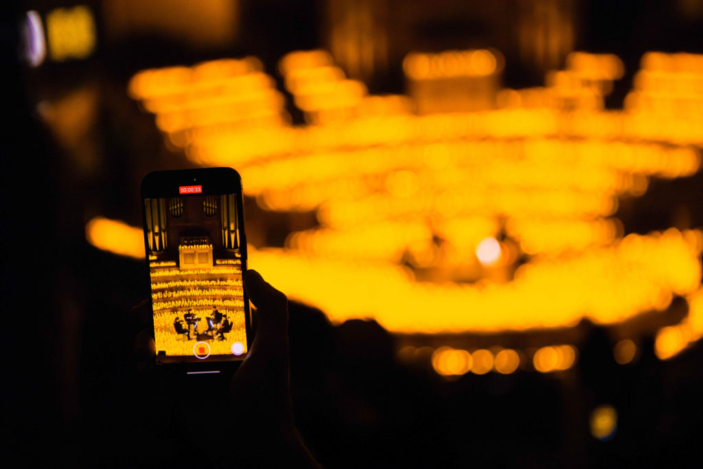 A mobile phone taking a photo of a Candlelight concert.