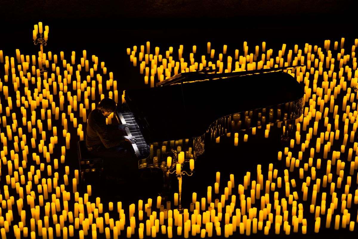 A pianist playing the piano by candlelight.