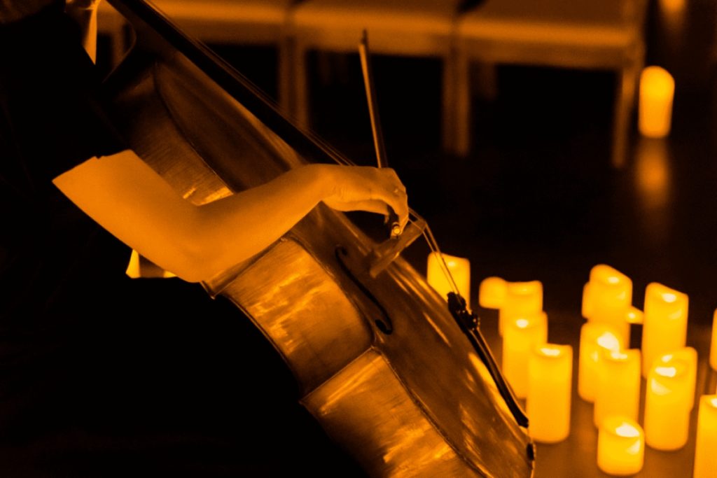 A close up of a musician playing the cello at a Candlelight concert