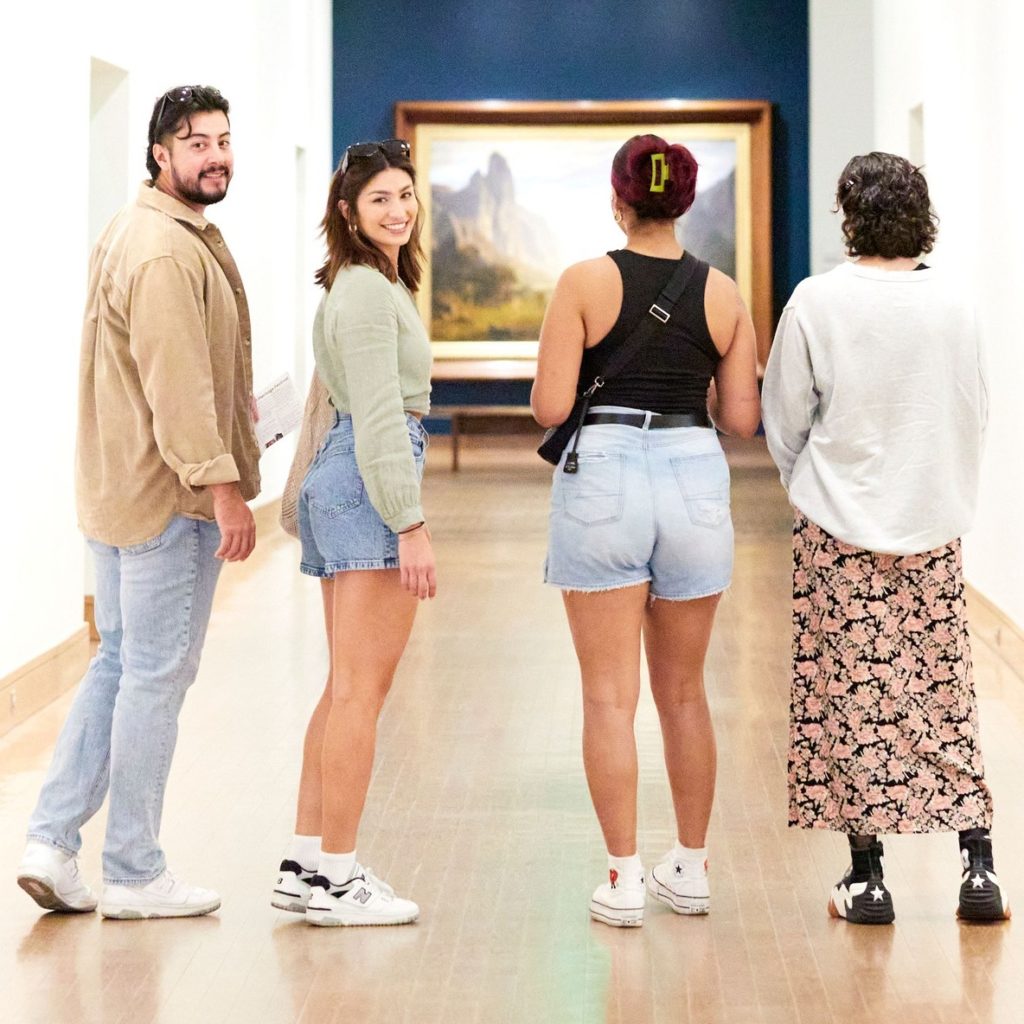 Four people look at paintings in the Birmingham Museum of Art