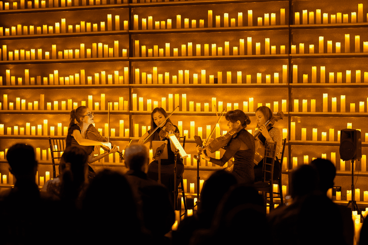 quarteto de cordas se apresentando à luz de velas