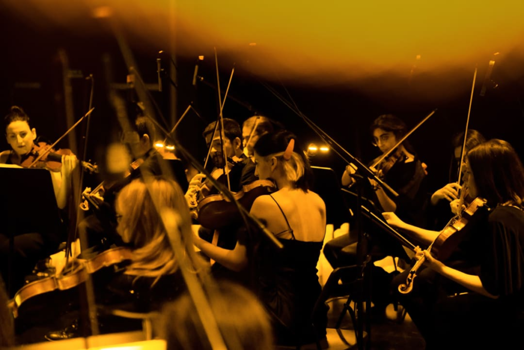 An orchestra performing by candlelight