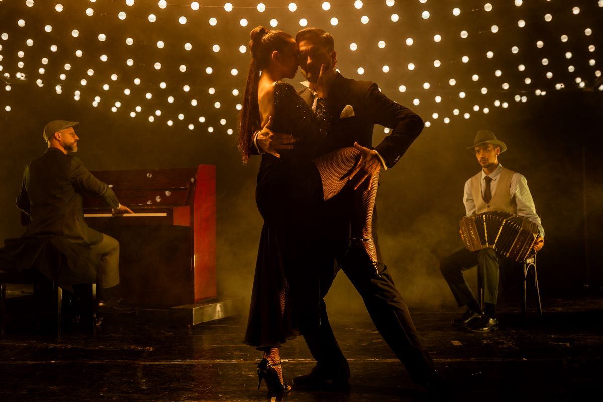 Un uomo che tiene la gamba di una donna contro il suo fianco mentre balla il tango.