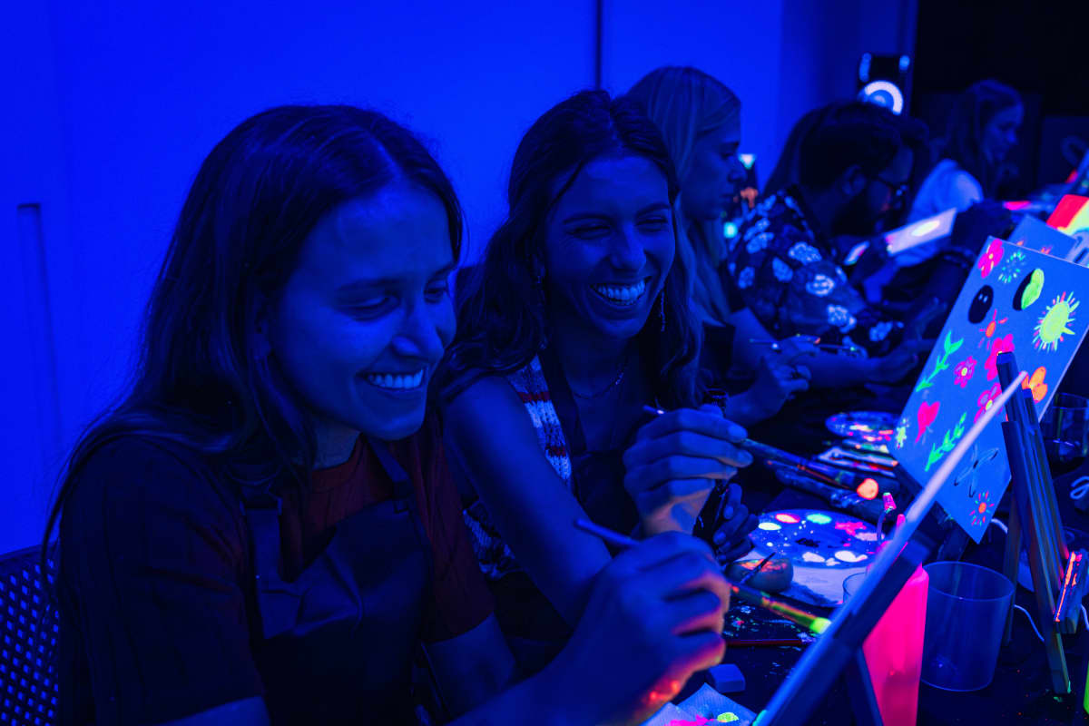 Two girls laughing at Neon Brush