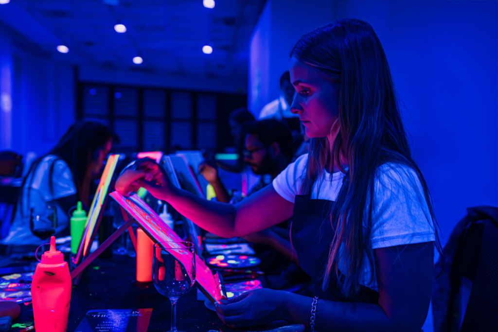 A woman painting with neon colors and paints