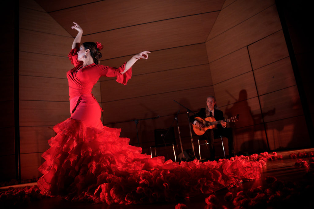 A woman dancing in a red dress at We Call It Flamenco.